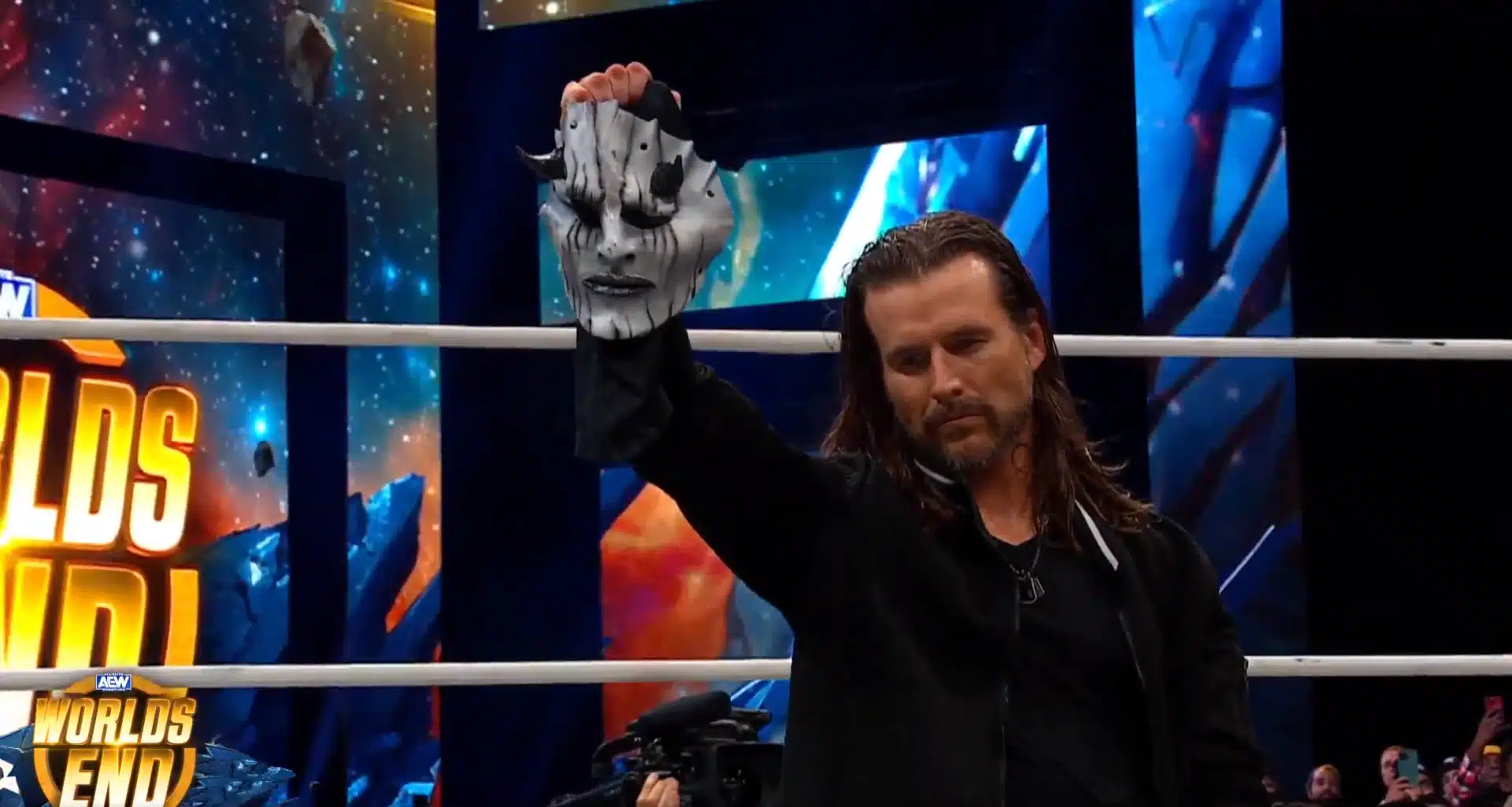Adam Cole is holding The Devil mask to confirm that he is this mysterious character