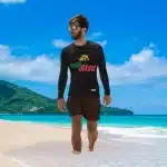 Our Dew Jitsu Rash guard here on a male model walking on the beach