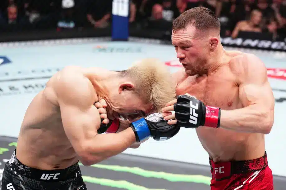 Petr Yan hooks under Song Yadong's chin during action in the octagon at UFC 299