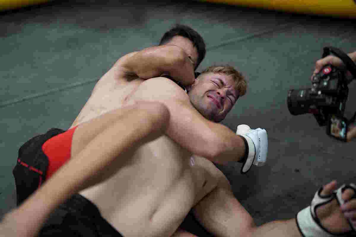 Grappler Applying Rear Naked Choke During Mma Training Demonstration